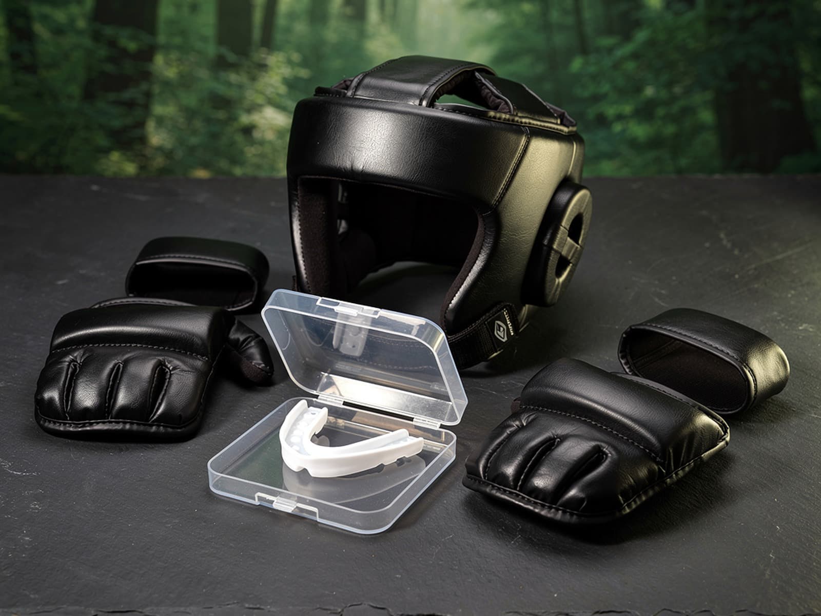 Black sparring headgear, open-palm pads, and mouthguard in case on dark slate: Cloud Forest sparring kit merchandise