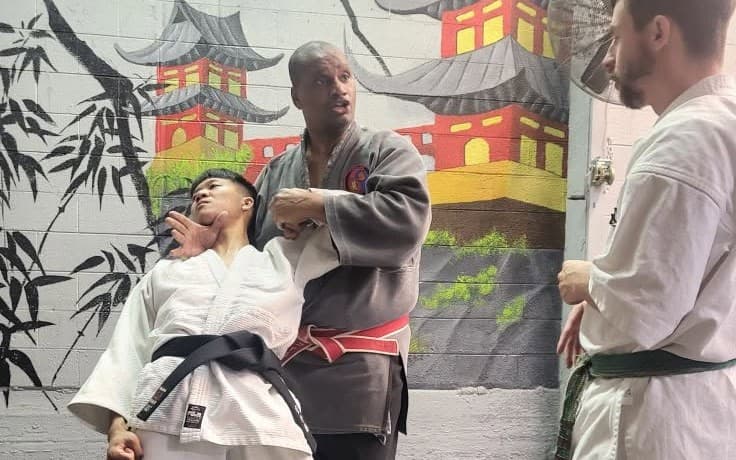 A Lyger Ryu instructor demonstrating a standing control on a student while another student watches